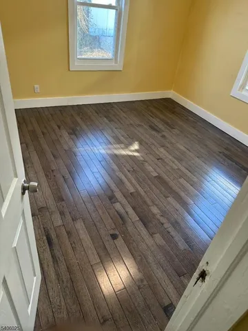 a view of a room with wooden floor and a ceiling fan
