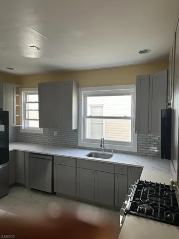 a kitchen with stainless steel appliances a sink a stove and a window