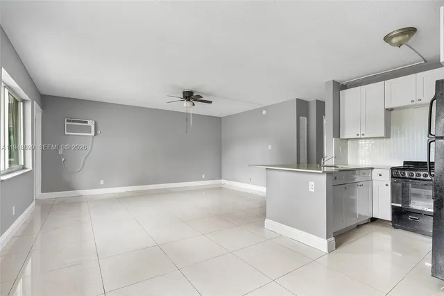 a view of kitchen with granite countertop cabinets and refrigerator