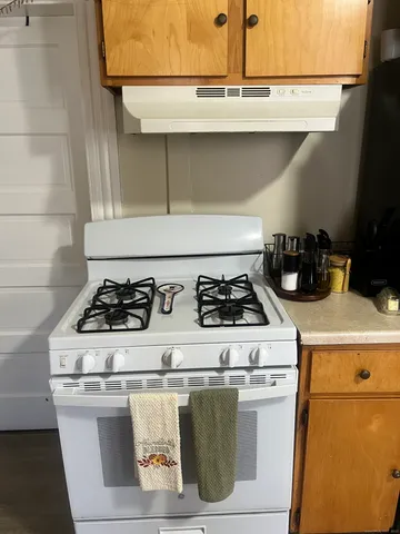 a white stove top oven sitting inside of a kitchen
