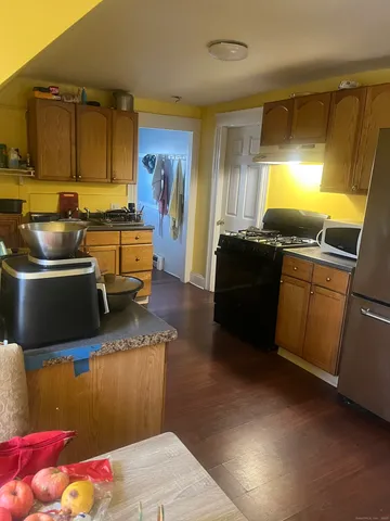 a kitchen with granite countertop a sink stove and refrigerator