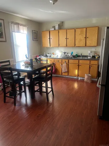 a kitchen with stainless steel appliances granite countertop wooden floors stove top oven and cabinets