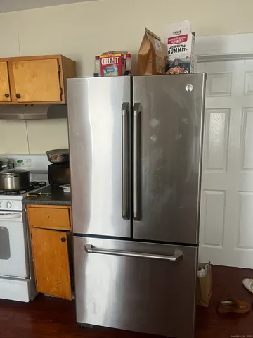 a white refrigerator freezer and a stove sitting inside of a kitchen