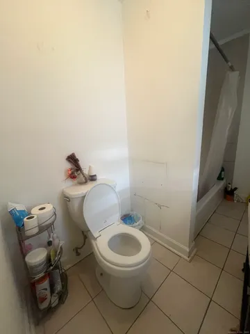 a white toilet sitting next to a bathroom sink and a mirror