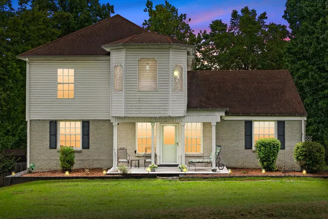 a front view of a house with a yard and trees