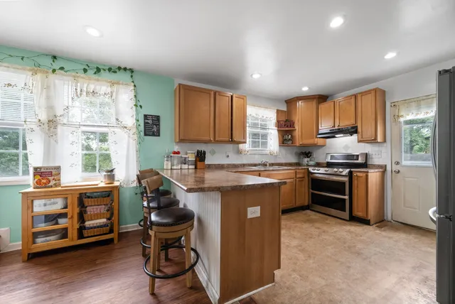 a kitchen with stainless steel appliances granite countertop a stove a sink and a microwave