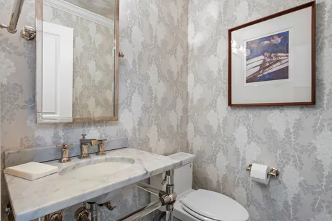 a bathroom with a sink a toilet and a mirror