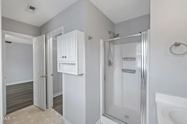 a bathroom with a shower and a glass door