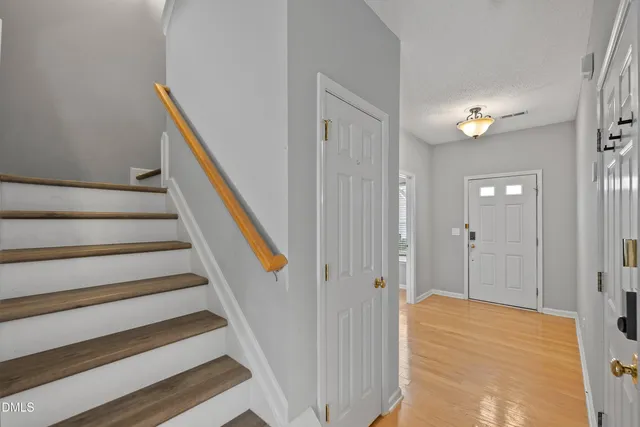 a view of a hallway with wooden floor and staircase