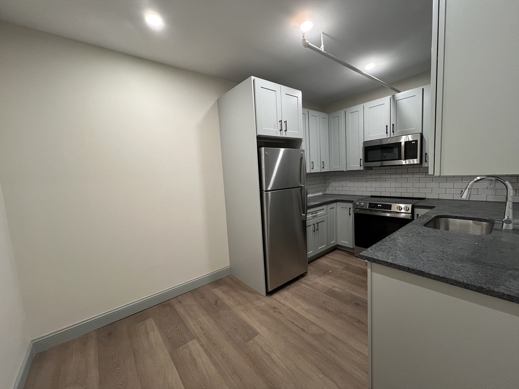 160 Seabury Street, Unit 3 Fall River, MA 02720 - Photo 2 of 12 a kitchen with granite countertop a refrigerator and a stove top oven