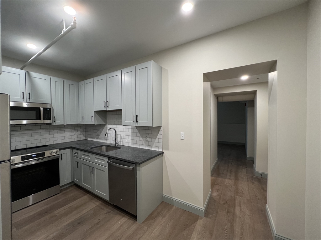 160 Seabury Street, Unit 3 Fall River, MA 02720 - Photo 3 of 12 a kitchen with stainless steel appliances granite countertop a stove a sink and a refrigerator