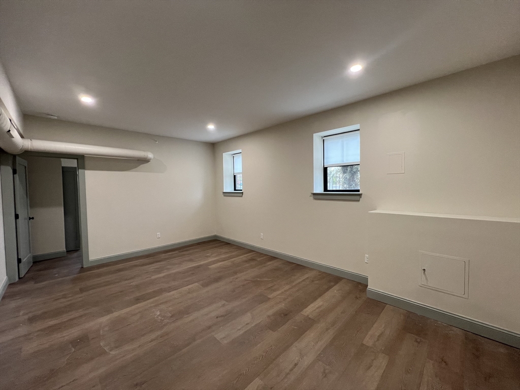 160 Seabury Street, Unit 3 Fall River, MA 02720 - Photo 4 of 12 an empty room with wooden floor and windows