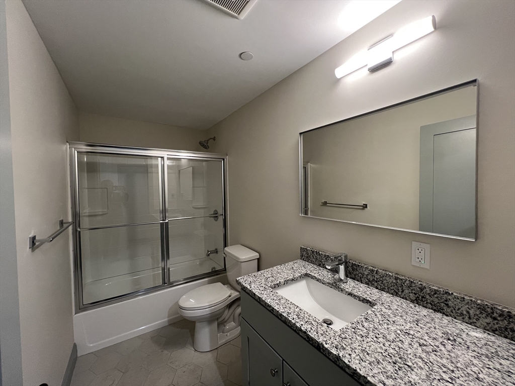 160 Seabury Street, Unit 3 Fall River, MA 02720 - Photo 8 of 12 a bathroom with a granite countertop sink toilet a mirror and shower