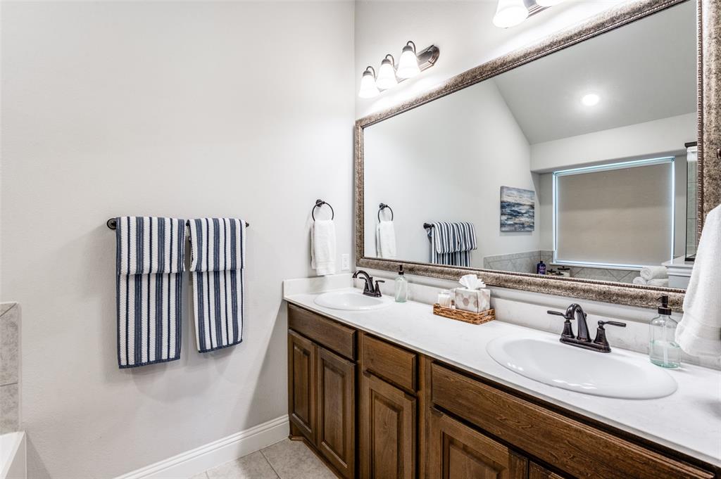 3011 Razorback Street Melissa, TX 75454 - Photo 18 of 25 a bathroom with a sink double vanity and a mirror
