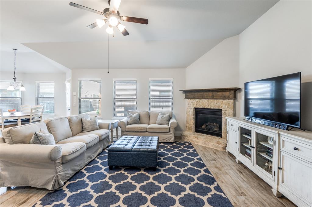 3011 Razorback Street Melissa, TX 75454 - Photo 3 of 25 a living room with furniture a flat screen tv and a fireplace
