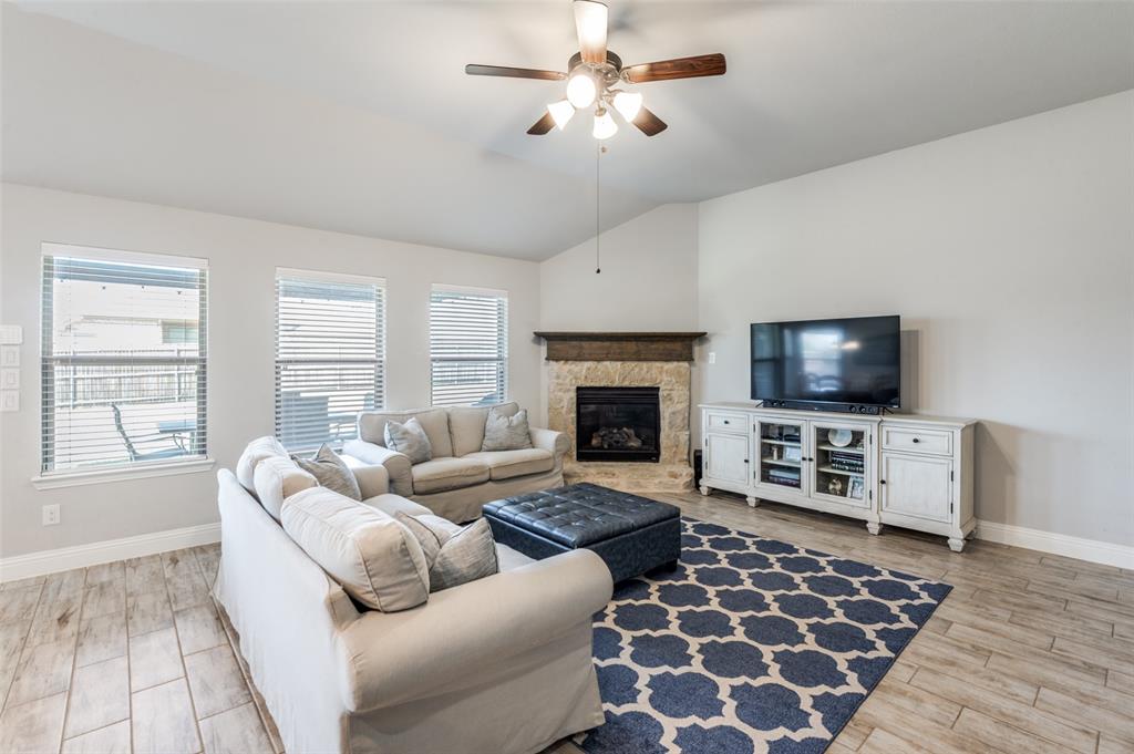 3011 Razorback Street Melissa, TX 75454 - Photo 5 of 25 a living room with furniture a flat screen tv and a fireplace