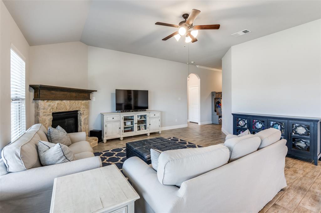 3011 Razorback Street Melissa, TX 75454 - Photo 6 of 25 a living room with furniture a fireplace and a flat screen tv