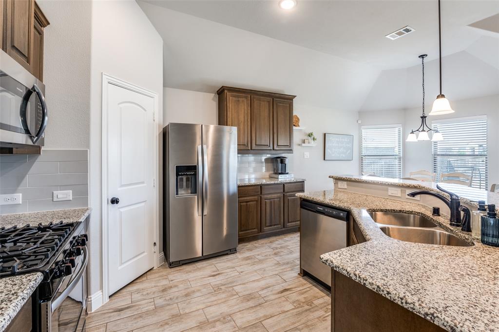 3011 Razorback Street Melissa, TX 75454 - Photo 8 of 25 a kitchen with stainless steel appliances granite countertop a sink stove and refrigerator