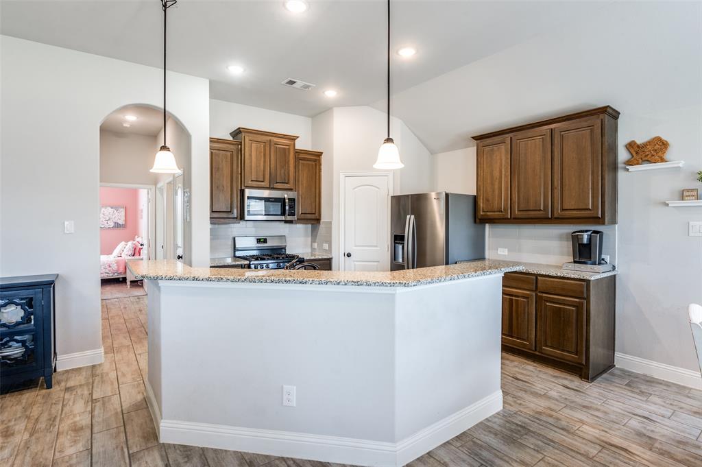 3011 Razorback Street Melissa, TX 75454 - Photo 10 of 25 a kitchen with stainless steel appliances granite countertop a sink a stove and a refrigerator