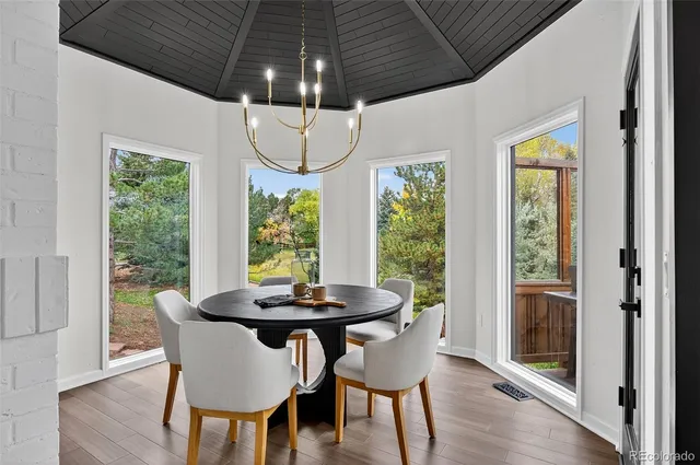 a kitchen with a table chairs refrigerator and window
