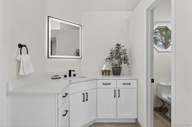 a view of an empty room with wooden floor and a fireplace
