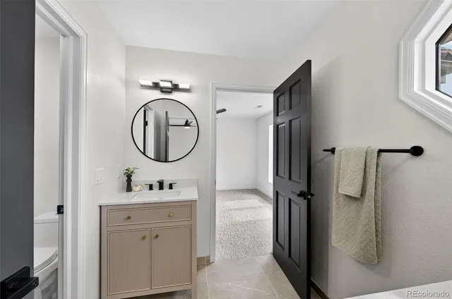 a bathroom with a granite countertop sink toilet a mirror a vanity and shower