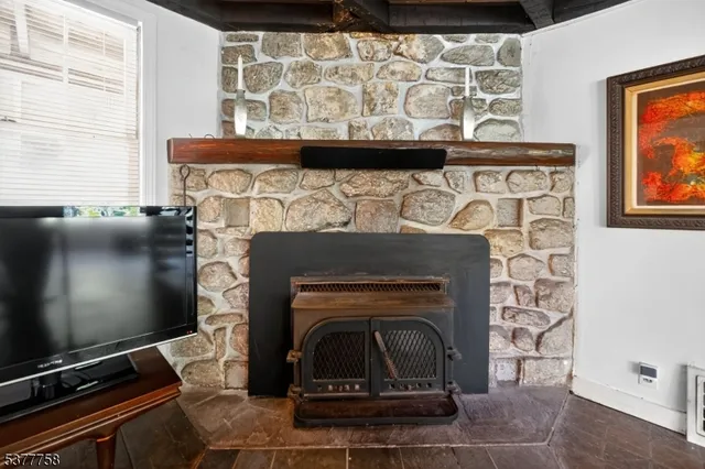 a living room with furniture and a flat screen tv with kitchen view