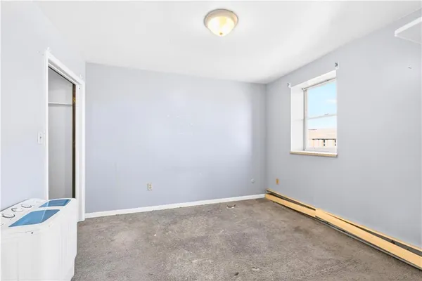 an empty room with closet and mirror
