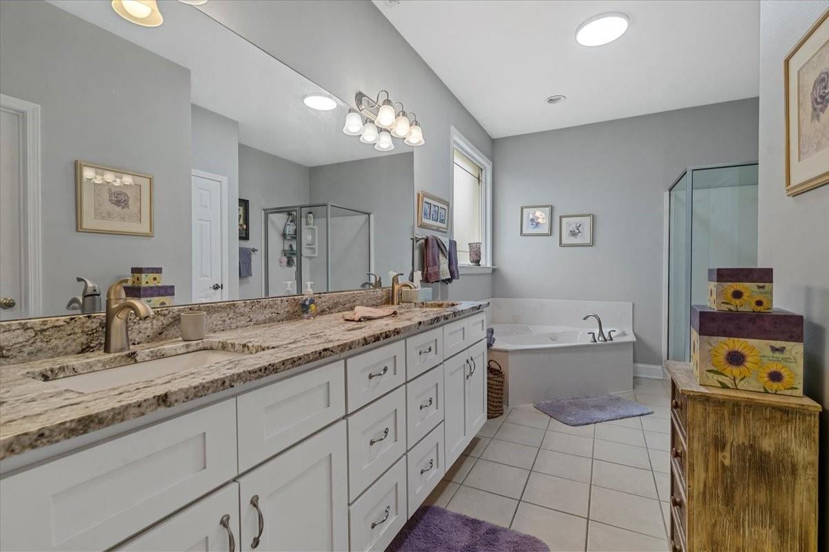 326 Point Carpenter Road Indian Land, SC 29707 - Photo 26 of 48 a spacious bathroom with a granite countertop sink a toilet mirror and bathtub