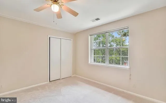 an empty room with a window and a fan