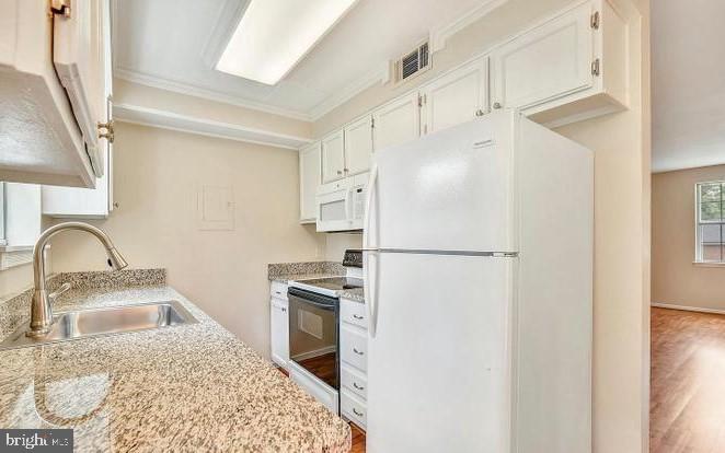 4615 B 28th Road South, Unit B Arlington, VA 22206 - Photo 2 of 24 a kitchen with stainless steel appliances granite countertop a refrigerator a sink a stove and white cabinets with wooden floor