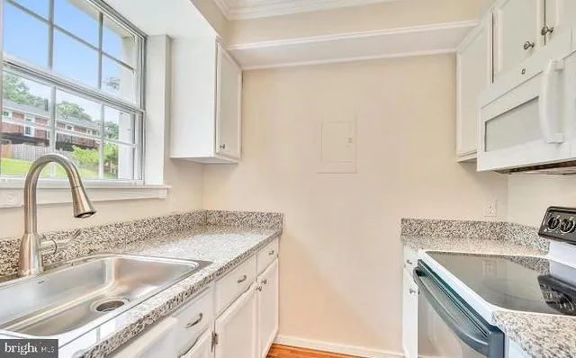 a kitchen with granite countertop a sink and a stove top oven