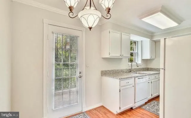 a kitchen with stainless steel appliances granite countertop a sink a stove cabinets and wooden floor