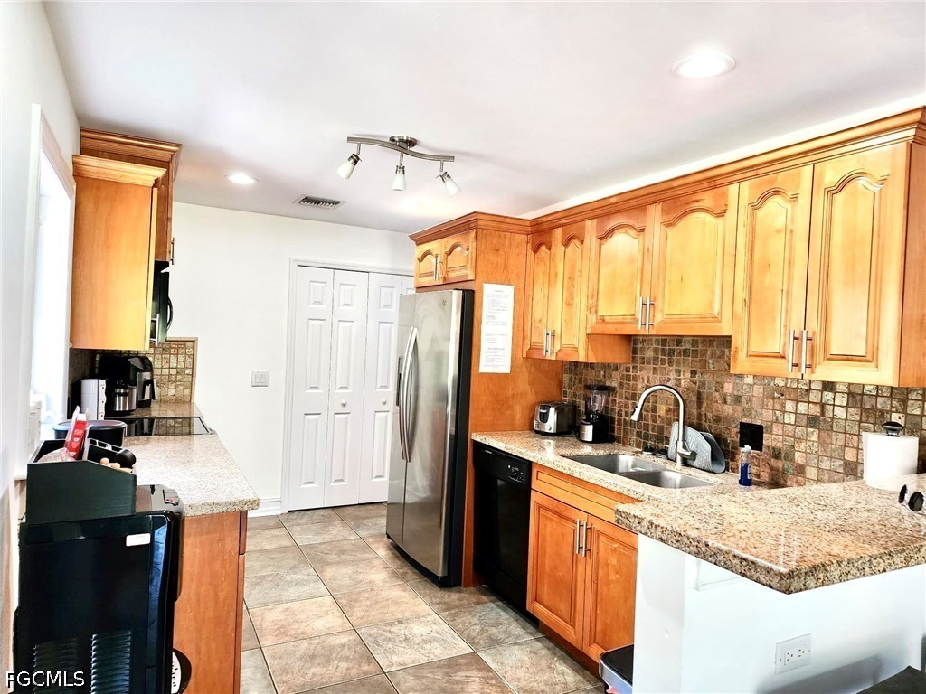 740 19th Street Southwest Naples, FL 34117 - Photo 33 of 35 a kitchen with stainless steel appliances granite countertop a sink counter space and a large window