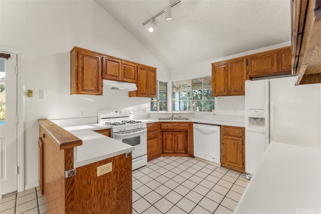 1856 Gird Road Fallbrook, CA 92028 - Photo 23 of 39 a kitchen with a refrigerator a stove top oven a sink and dishwasher