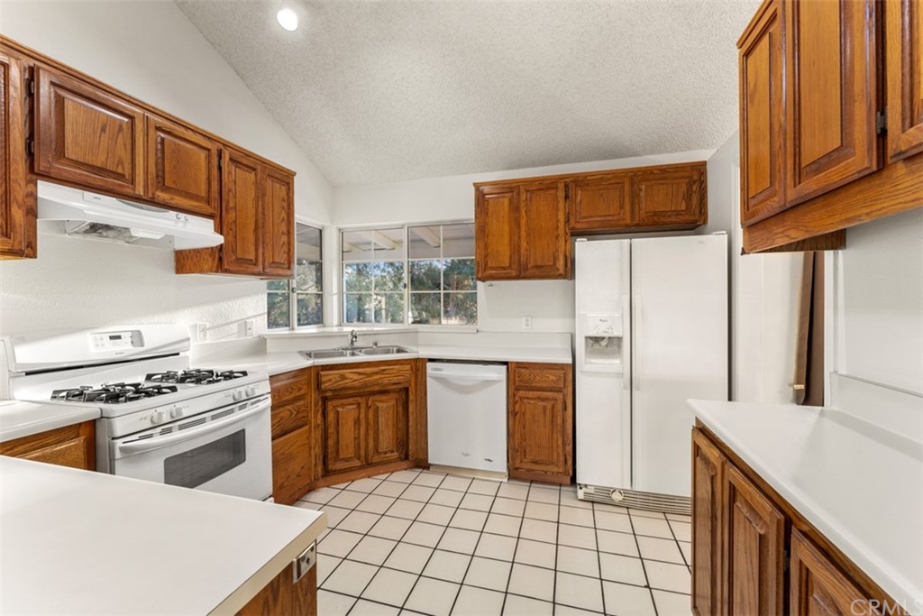 1856 Gird Road Fallbrook, CA 92028 - Photo 24 of 39 a kitchen with stainless steel appliances granite countertop a stove a sink dishwasher and a refrigerator