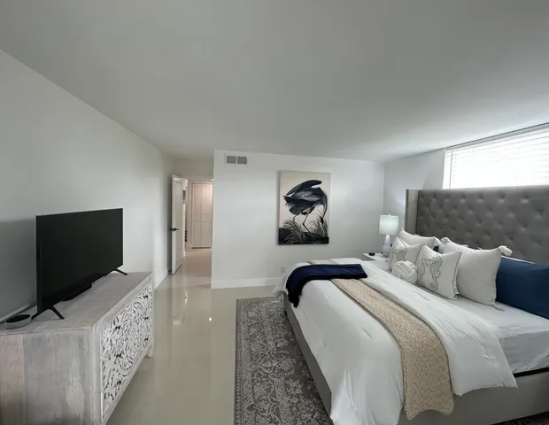 a bedroom with bed and a flat screen tv