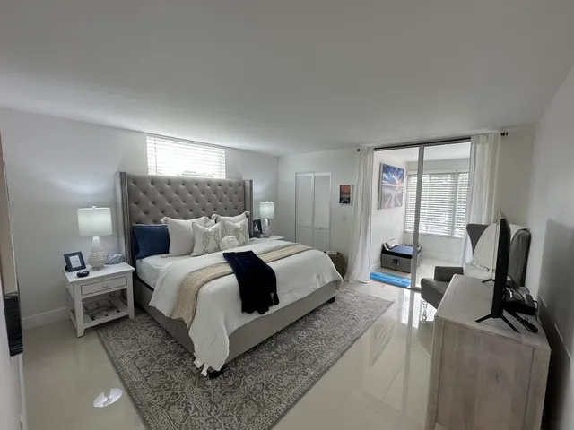 a bedroom with a bed chair and window