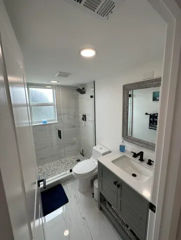 a bathroom with a sink a toilet and shower