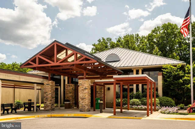 a front view of a building with a garden and pathway