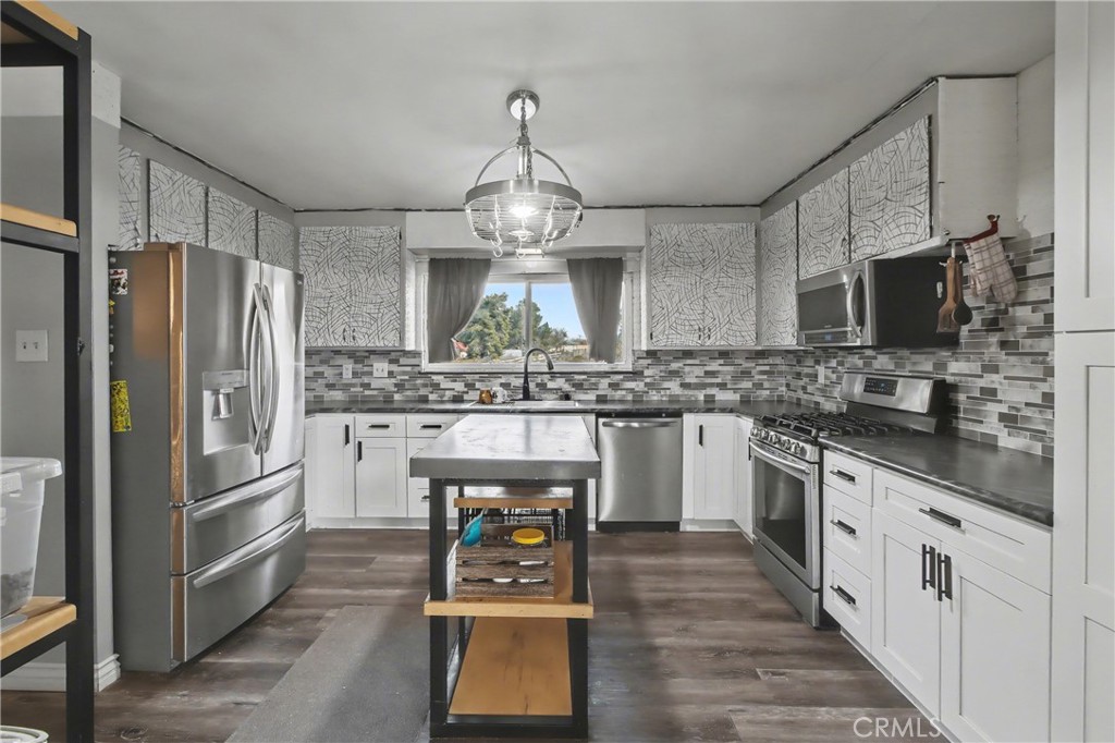 14798 Keota Road Apple Valley, CA 92307 - Photo 7 of 27 a kitchen with stainless steel appliances a refrigerator sink and cabinets