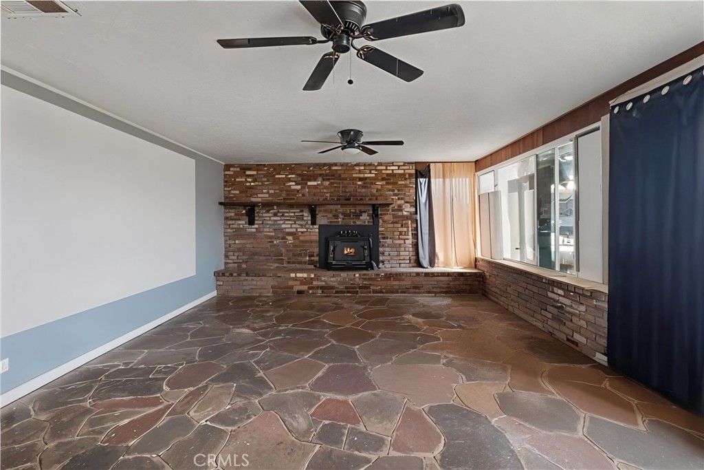 14798 Keota Road Apple Valley, CA 92307 - Photo 9 of 27 a view of an empty room with a fireplace and a window