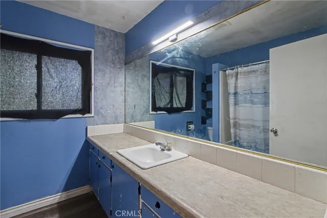 a bathroom with a granite countertop sink and a mirror