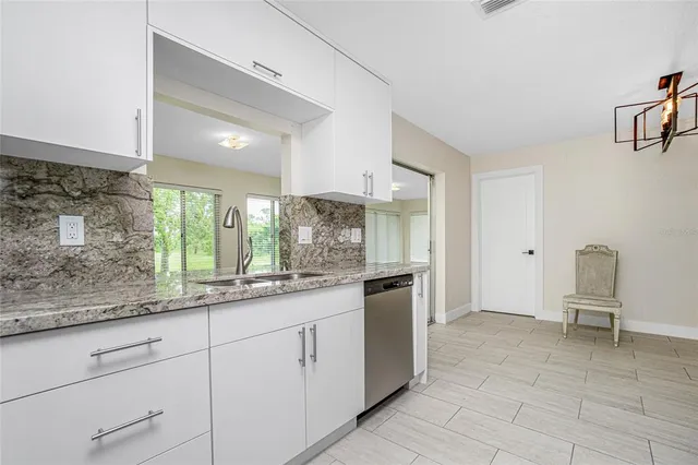 a kitchen with granite countertop white cabinets and white appliances