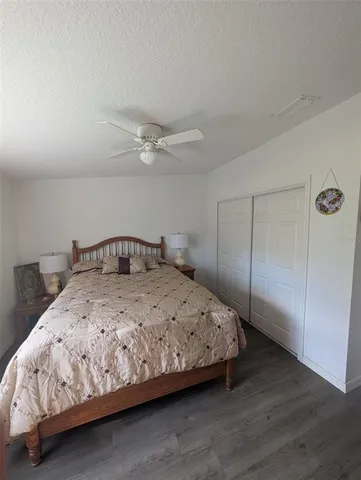 a bedroom with a bed and a ceiling fan