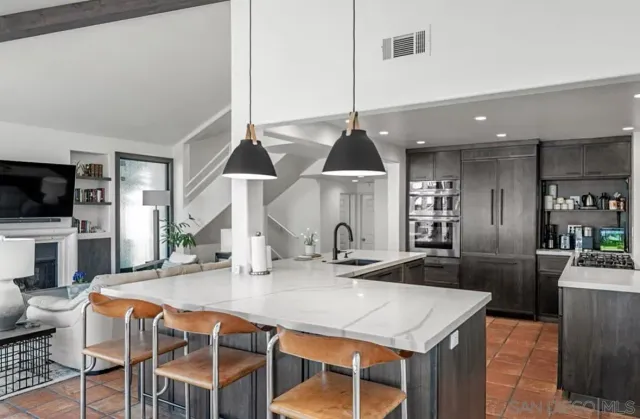a kitchen with kitchen island granite countertop a sink a counter top space and appliances