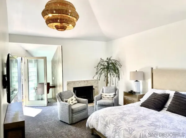 a bedroom with a large bed and a chandelier