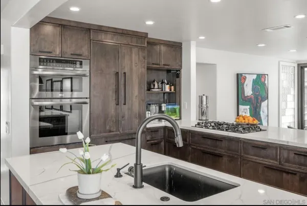 a kitchen with stainless steel appliances granite countertop a refrigerator and a stove