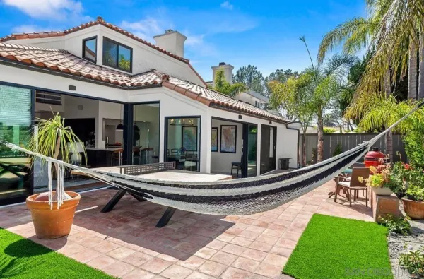 a view of a house with backyard and sitting area