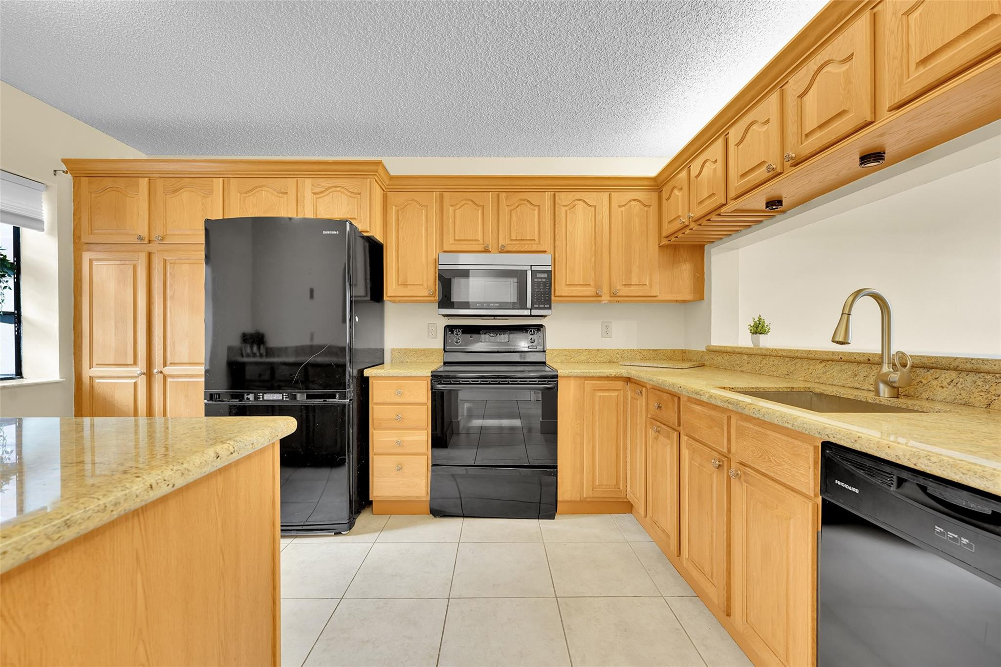 10761 Northwest 14th Street, Unit 281 Plantation, FL 33322 - Photo 4 of 33 a kitchen with granite countertop a sink stove and refrigerator